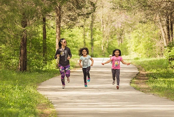Mother running with her two daughters on hiking trails in Springfield, MO
