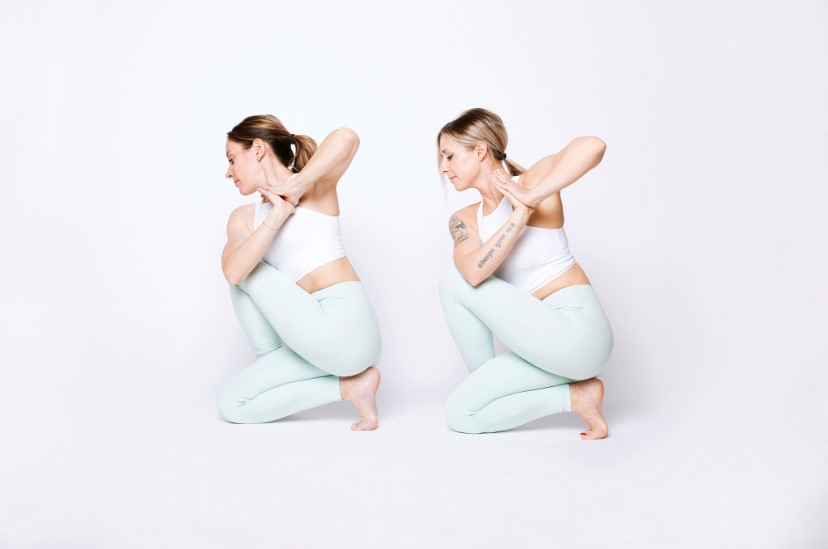 Two women participating in yoga poses against a plain white background