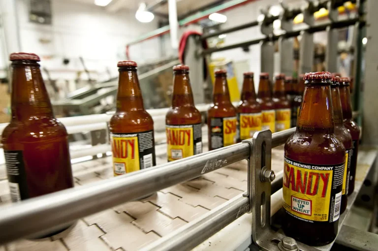 Bottles of Mothers Brewing Company beer being processed