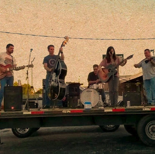 Group of people performing music standing on flatbed trailer